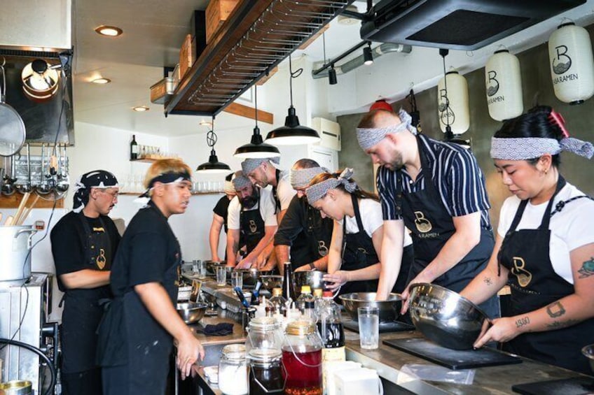 Eine Gruppe Köche bereitet in einer Küche Essen zu. 5