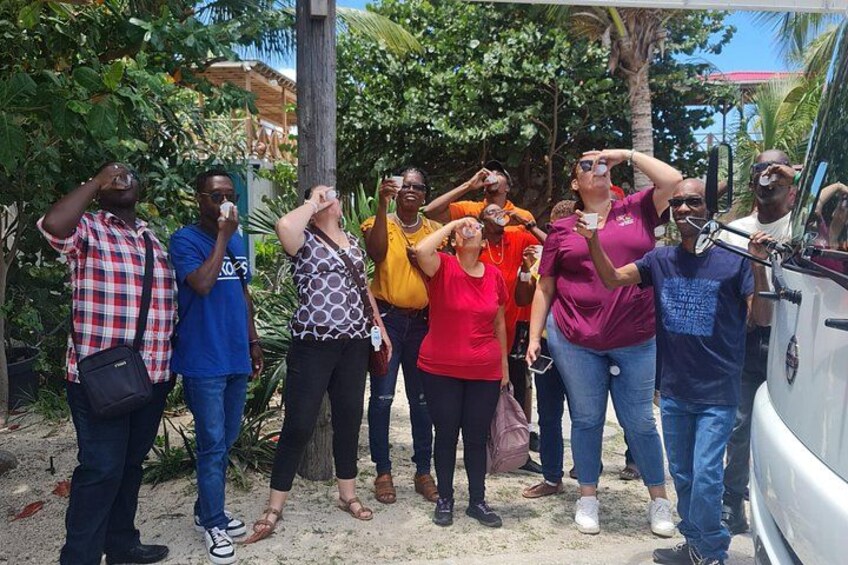 A group of people standing outdoors, some taking photos, with a vehicle parked nearby. 4
