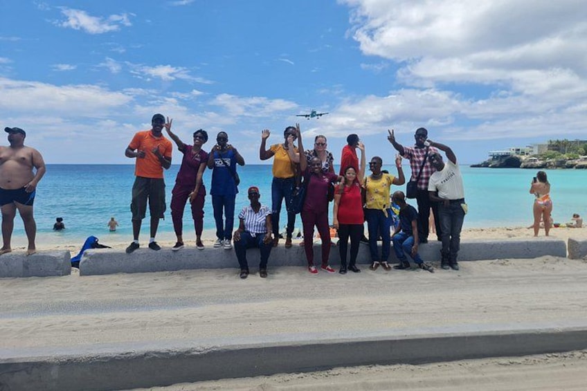 A group of people standing on a beach with the ocean in the background. 3