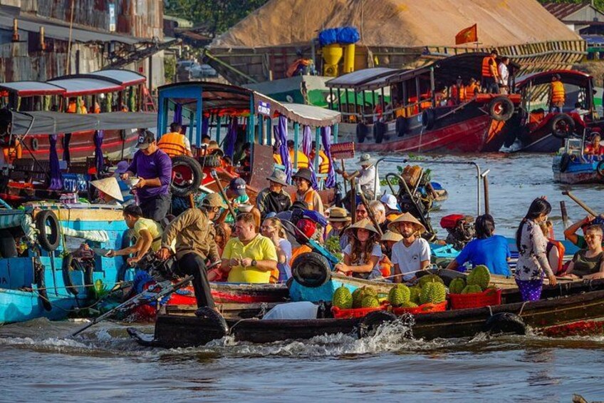 A crowded river with people on boats, some wearing hats, and a few boats docked at the shore. 3