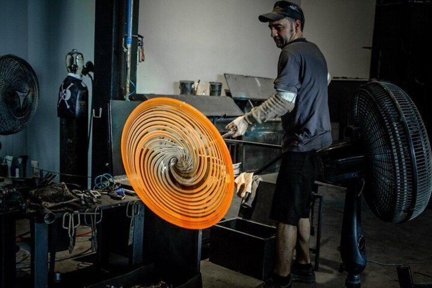 Una persona trabajando con un ventilador naranja grande en un taller. 3