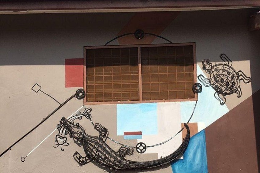 A wall with a window, a turtle illustration, and a rope-like structure. 3