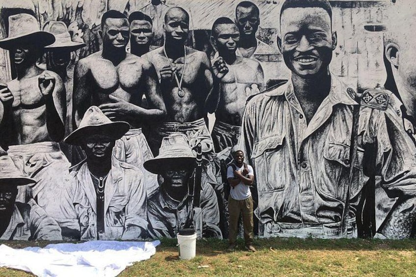 A mural with people and a large figure in the foreground. 2