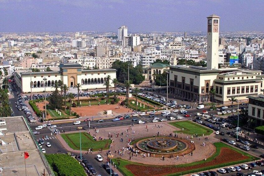 A cityscape with a central square, a prominent clock tower, and surrounding buildings. 4