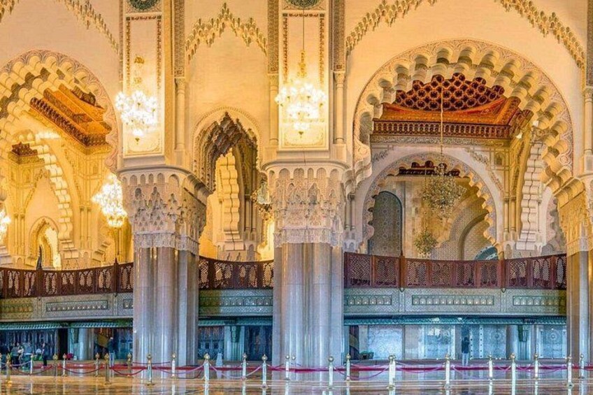 An ornate interior with arches, columns, and chandeliers. 4