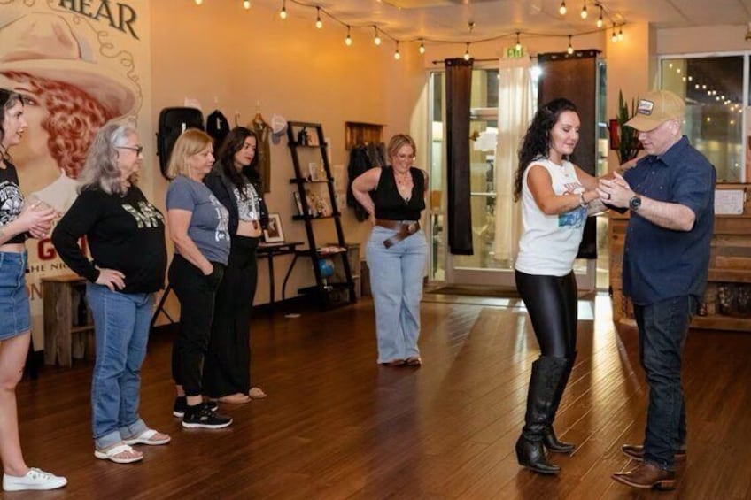 Un grupo de personas en un estudio de baile con suelos de madera y un mural en la pared. 4