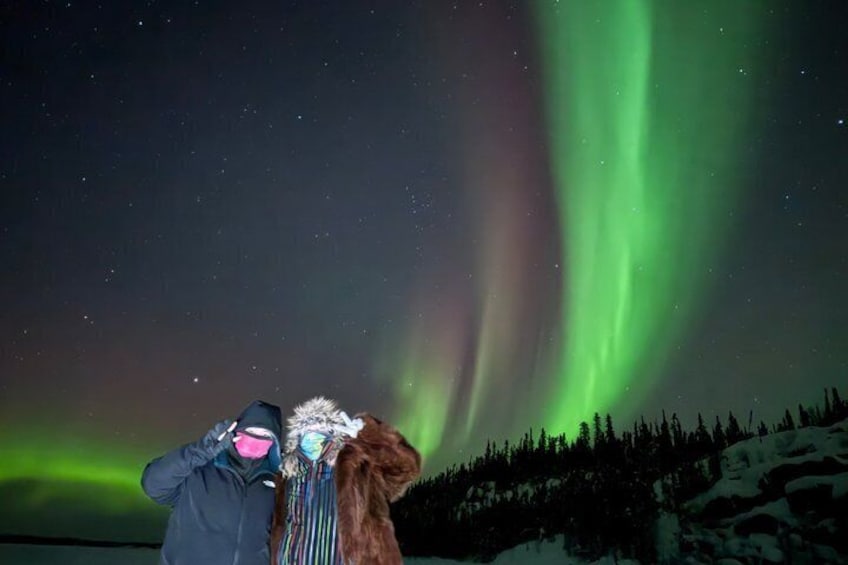 Eine Person fotografiert das Nordlicht mit einem Hund. 2
