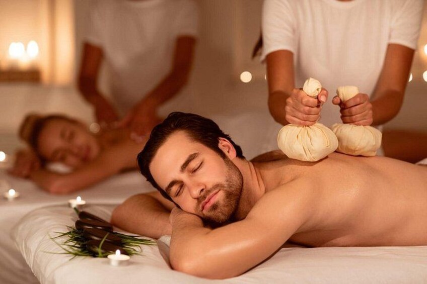 A person receiving a massage with a therapist applying pressure with a towel. 1