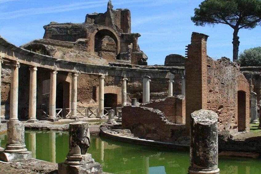 Ancient ruins with columns and a fountain. 5