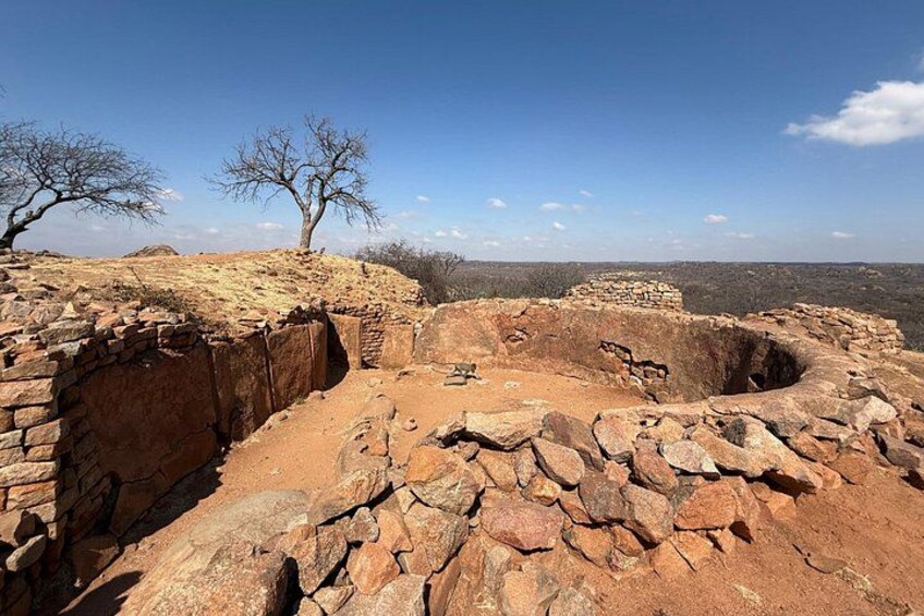 Ruinas antiguas con muros de piedra y una gran estructura circular. 4
