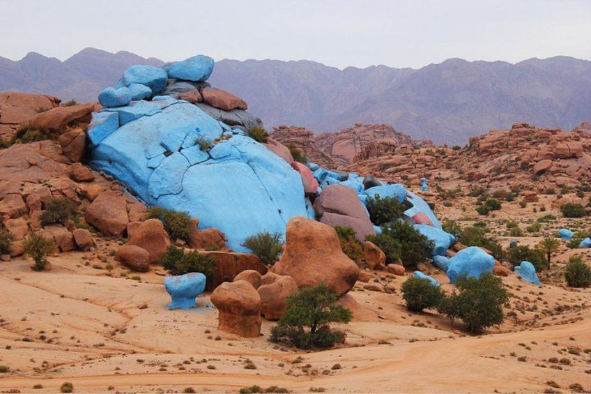 A desert landscape with large rock formations and sparse vegetation. 2