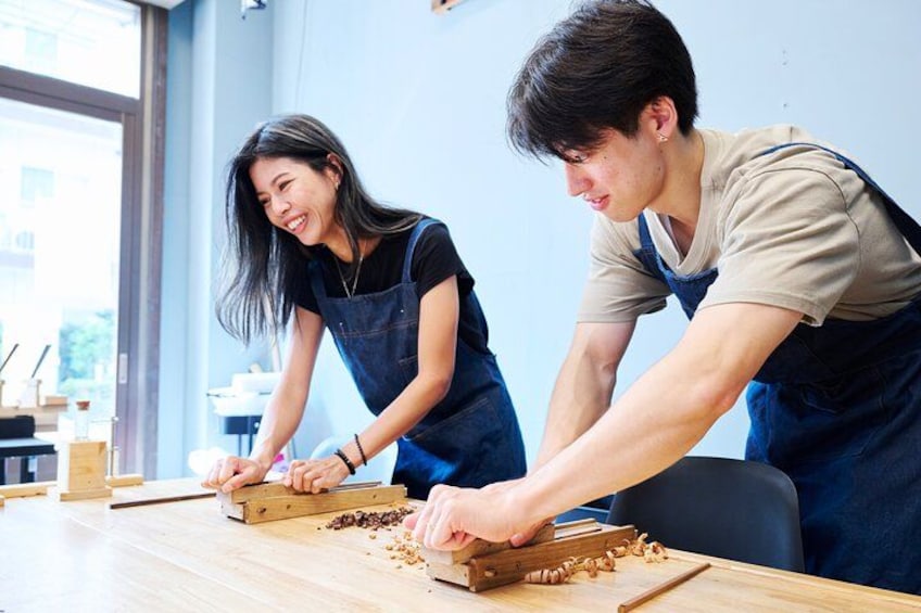 Deux personnes travaillent ensemble autour d’une table en bois, peut-être dans un atelier ou une cuisine. 5