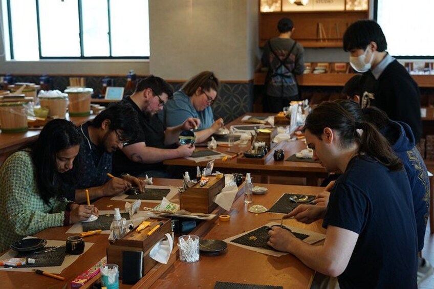 A group of people engaged in a painting activity at a table. 5