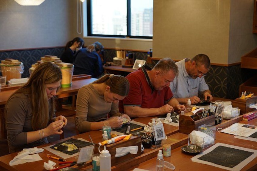 People seated at tables in a restaurant, engaged in various activities. 4