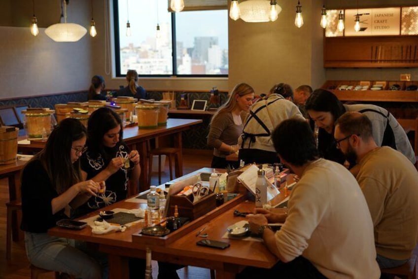 A group of people dining at a restaurant with wooden tables and hanging lights. 3