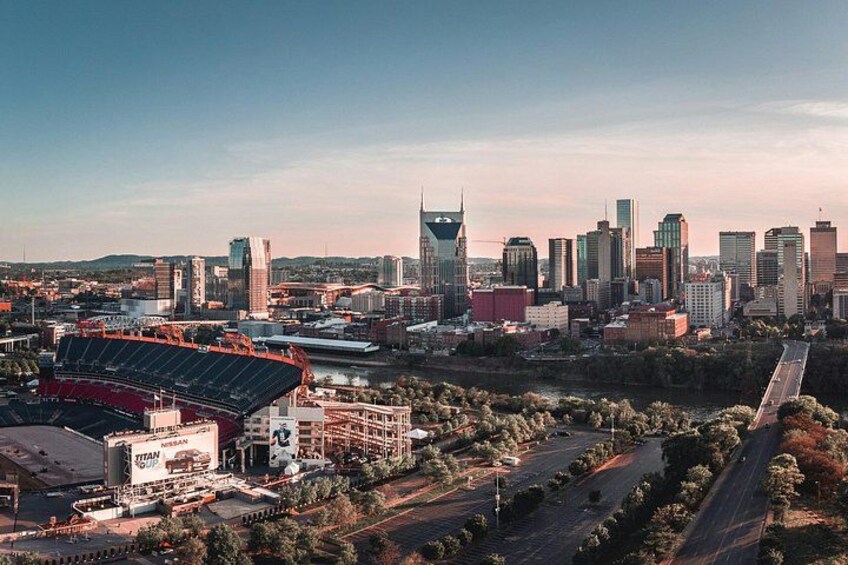 A city skyline with a prominent stadium and a river. 4