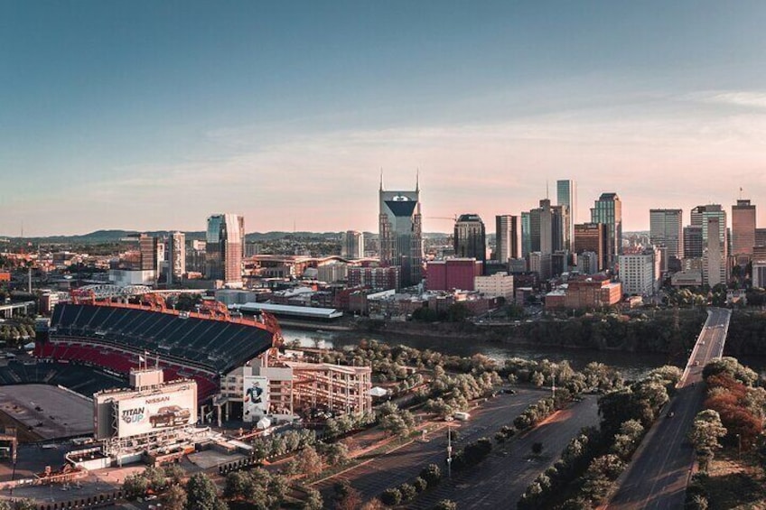 A city skyline with modern buildings, a stadium, and a river. 2