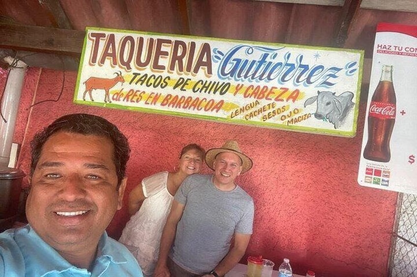 A restaurant with a sign advertising tacos and barbecue. 2