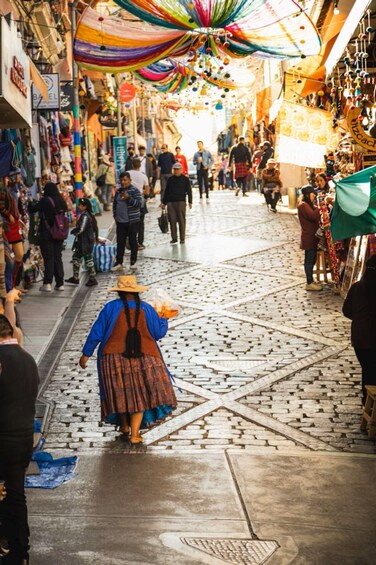 A bustling market street with people walking and vendors selling goods. 2