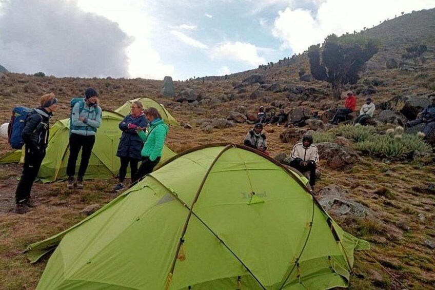 A group of people around tents in a mountainous area. 3