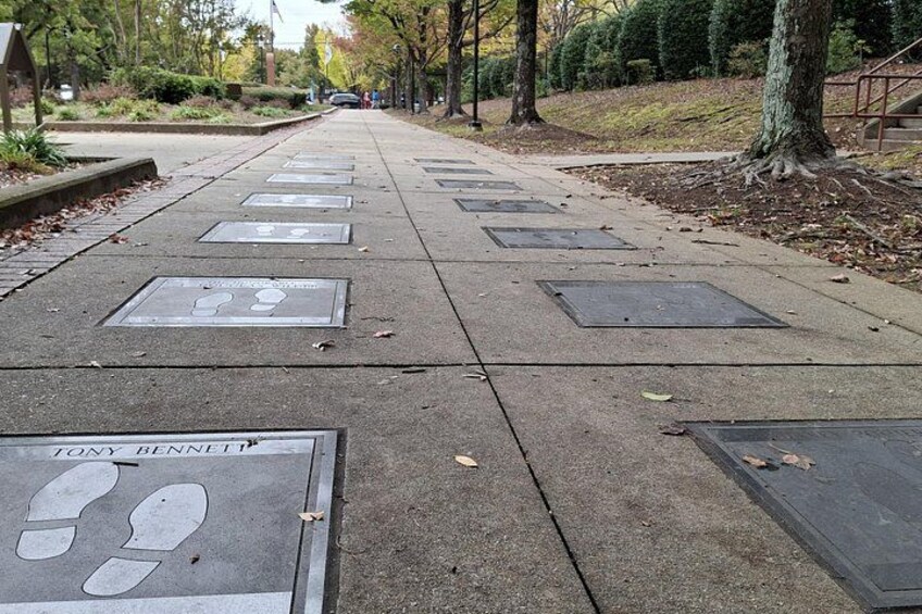 A sidewalk with tactile paving and a plaque reading 'TONY BENNETT'. 3