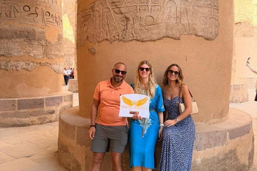 Drei Personen stehen vor einer altägyptischen Säule mit Hieroglyphen. 2