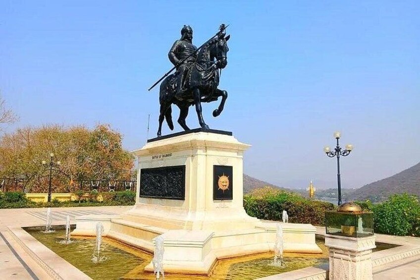 A statue of a man on horseback, a fountain, and a clear sky. 1