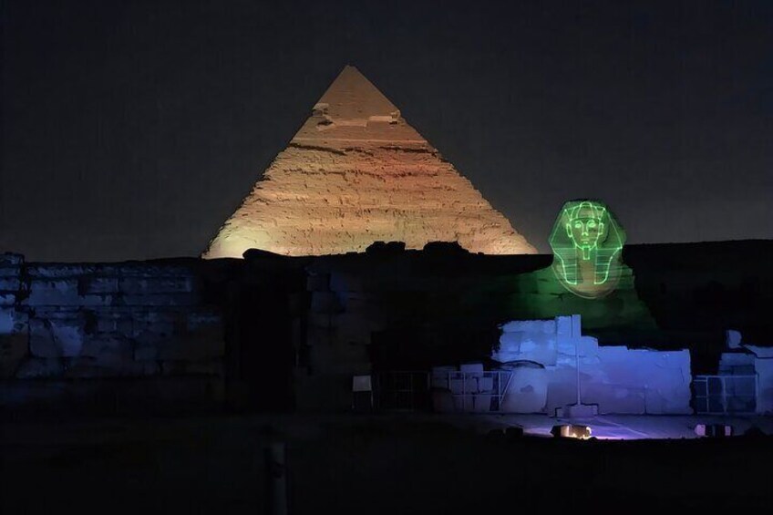 Eine Pyramide, nachts beleuchtet mit einer grünen Lichtprojektion eines Gesichts. 3