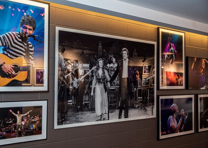 A wall with framed photographs of musicians and bands. 5