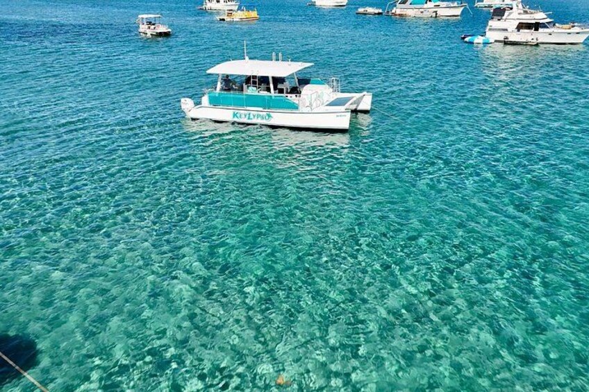 Une mer d’un bleu profond où voguent plusieurs bateaux, dont un bateau blanc et bleu appelé «
Keylup
». 3