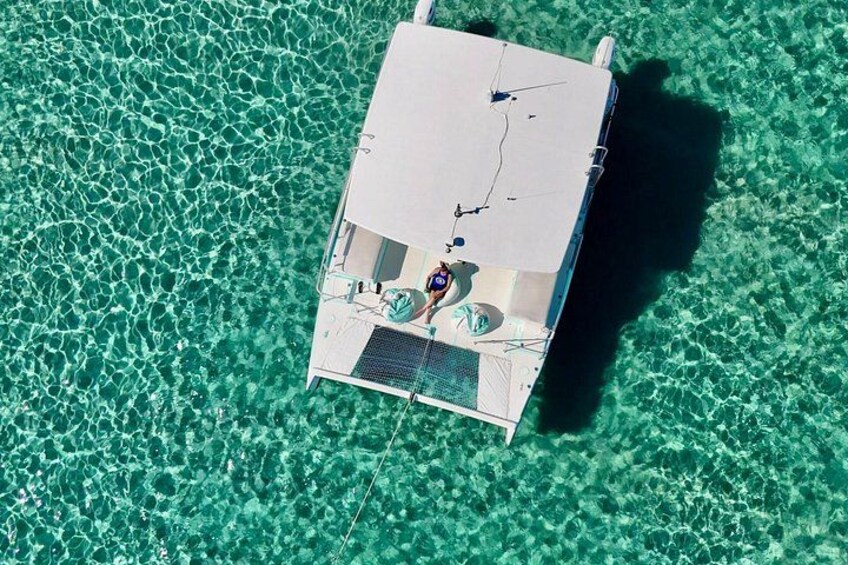 “Our catamaran anchored in shallow emerald waters—your starting point for swimming and exploring Peanut Island.” 2