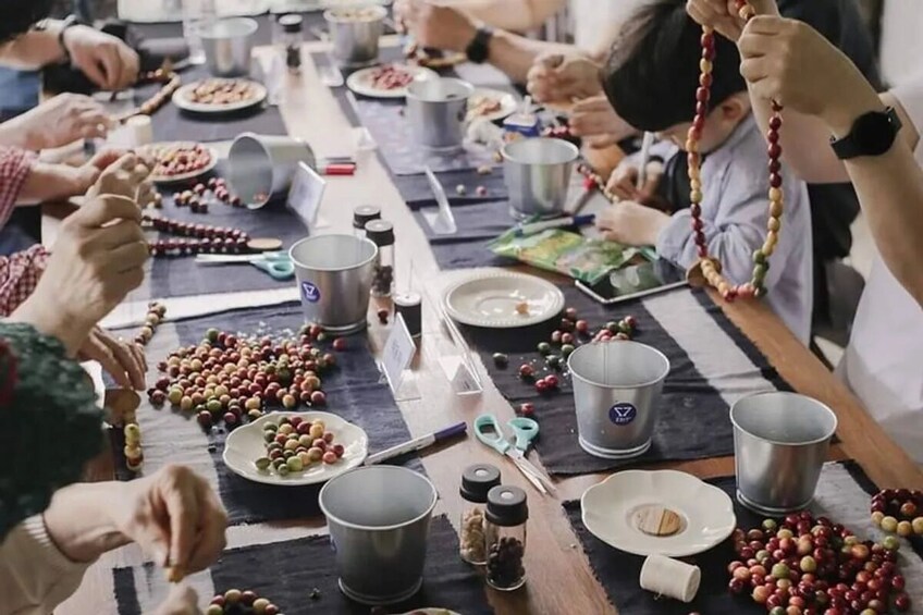 A group of people engaged in a communal activity, possibly a cooking or food preparation event, with various utensils and containers on a table. 3