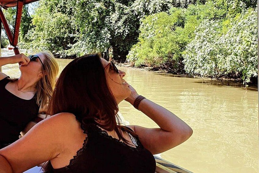 Two people on a boat, a river, and trees in the background. 5