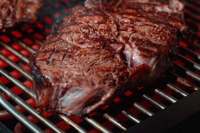 A grilled steak with visible grill marks on a grill. 4