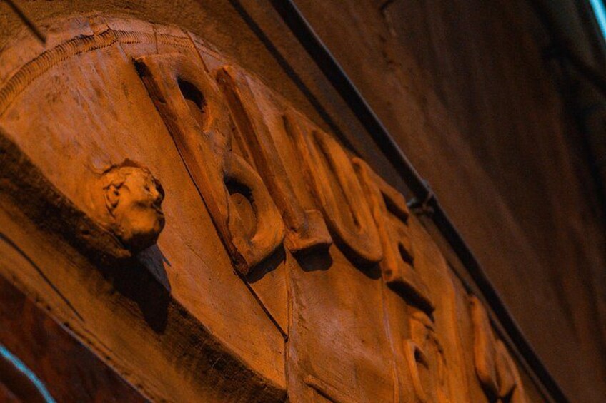 A carved wooden surface with the word 'BLUE' and a lion's head. 2