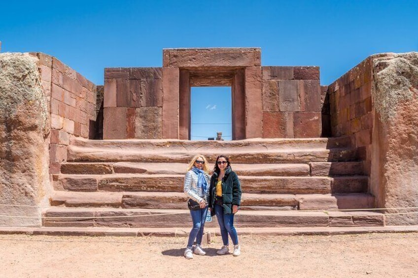 Two people standing in front of ancient stone steps leading to a doorway. 5