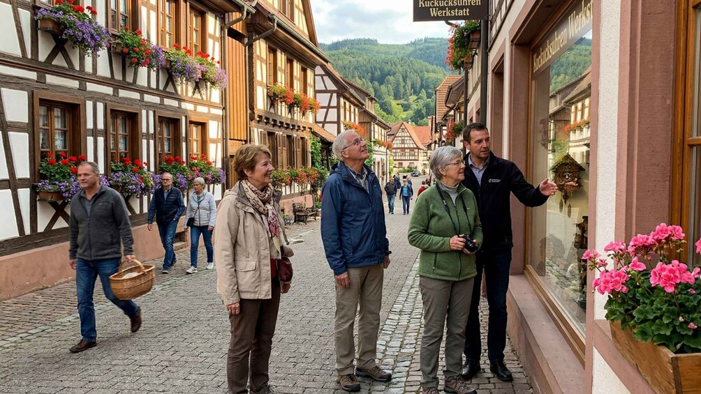 A cobblestone street lined with traditional half-timbered buildings, a sign reading 'Kuckucksuhren Werkstatt,' and people walking. 2