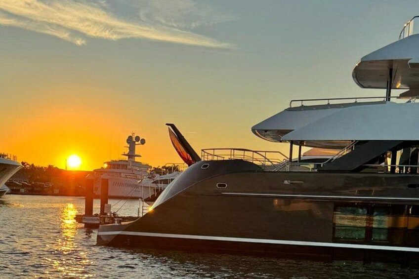 Eine große Yacht liegt im Sonnenuntergang in einer Marina vor Anker. 2