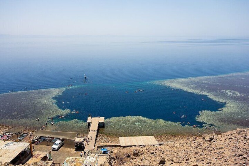 A coastal area with a large body of water, a pier, and a sandy beach. 1