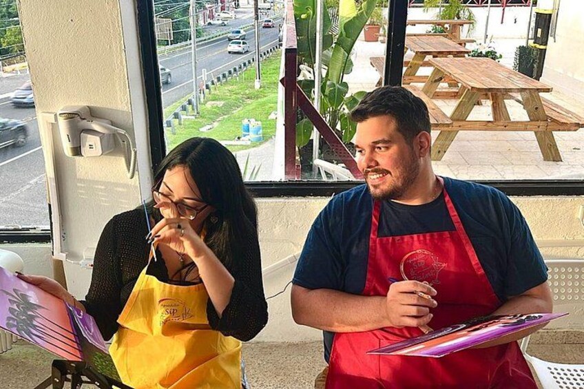 Two people wearing aprons, one holding a clipboard and the other holding a menu. 2