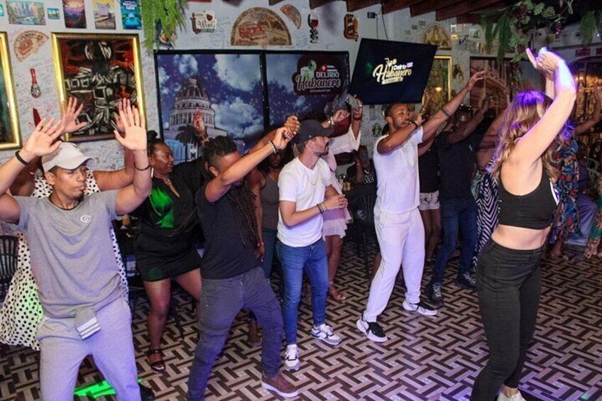 A group of people dancing in a room with patterned flooring and wall decorations. 3