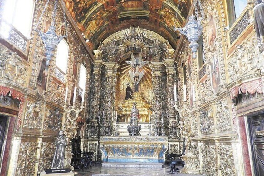 An ornate church interior with detailed carvings and a central altar. 4
