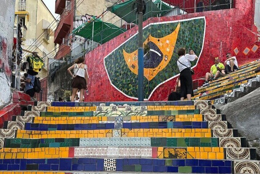 A staircase with colorful mosaic tiles and a large emblem. 1