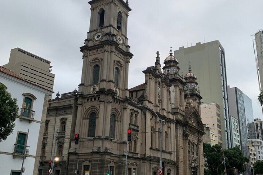 A historic church with a prominent bell tower and ornate architecture, surrounded by modern buildings. 5