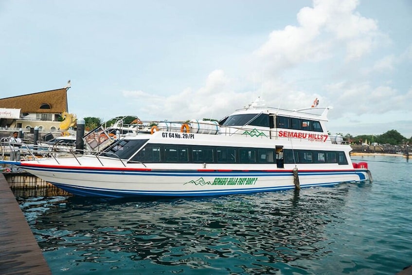 Un bateau blanc et bleu, baptisé « SEMABU HILLS FAST BOAT Y », était amarré à un quai. 1