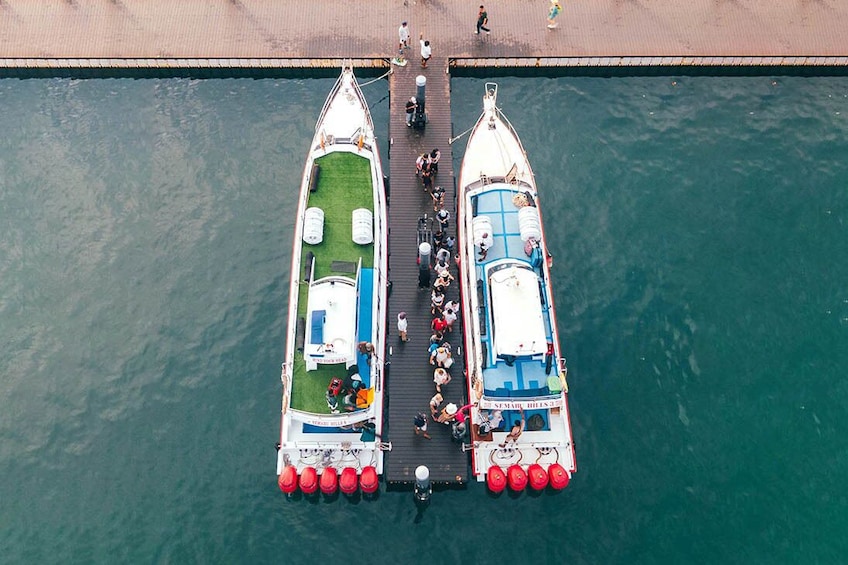 Deux bateaux étaient amarrés à un quai, et des gens se déplaçaient entre les deux. 3