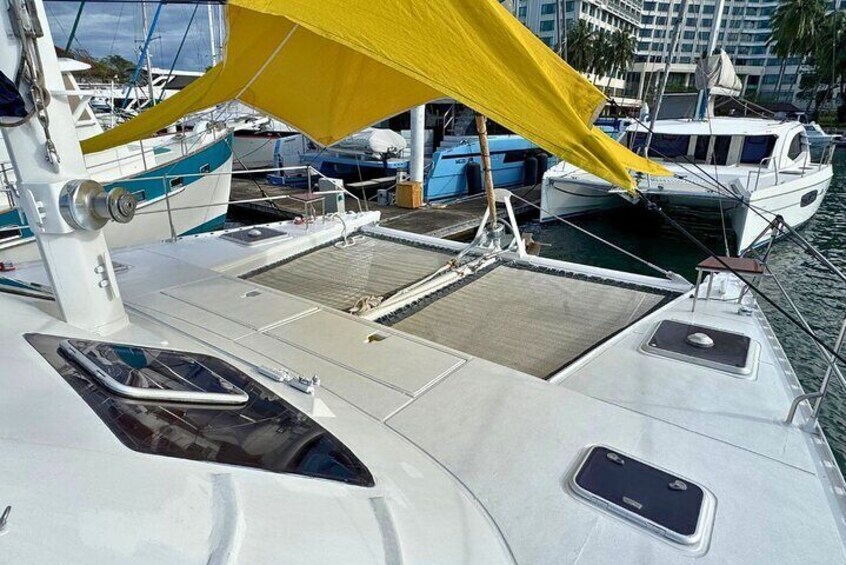 A boat deck with a yellow canopy, a steering wheel, and a small window. 3