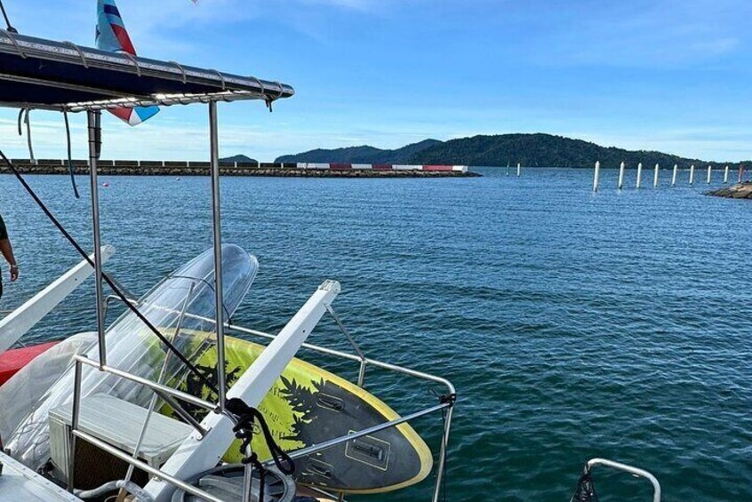 A boat with a clear view of the water and a distant shoreline with a forested hill. 4