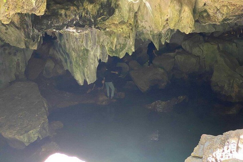 En grotta med stalaktiter, stalagmiter och en person som utforskar den. 5