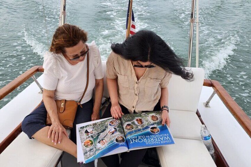 Two people on a boat reading a magazine. 3